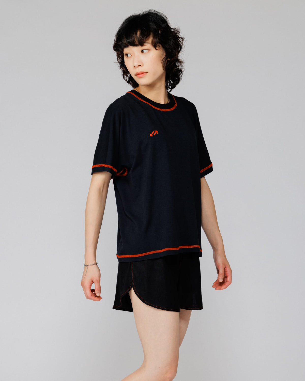 Model wearing Outnback Bog Tee in black, three-quarter front view turning